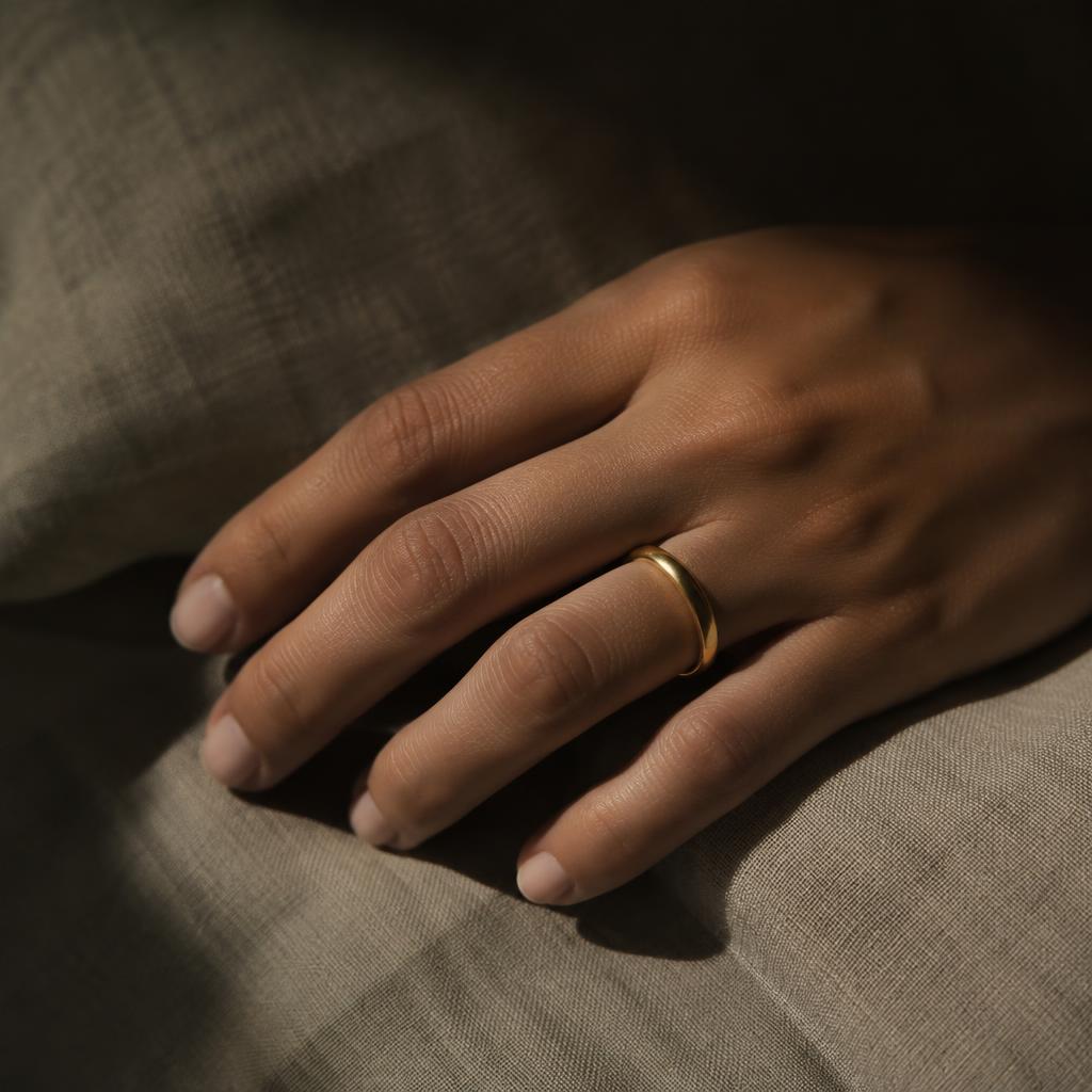 Plain gold band worn on a hand